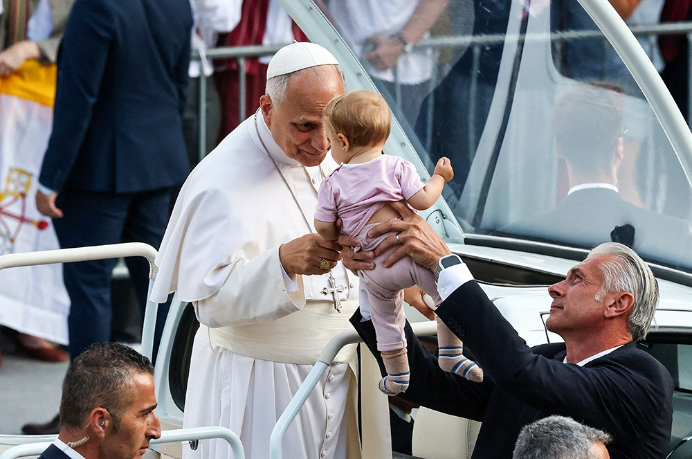 Pope Leo XIV blesses a child as he arrives to attend a prayer vigil at the Lluis Companys Olympic Stadium, during his apostolic journey, in Barcelona, Spain, June 9, 2026. (OSV News/Reuters/Yara Nardi)
