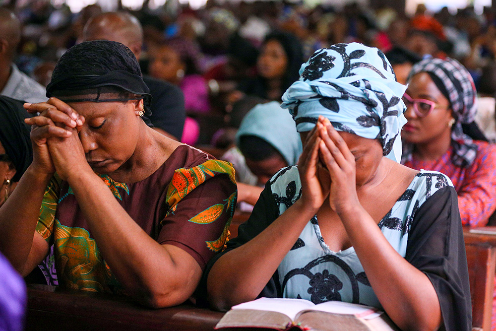 A woman is pictured in a file photo praying during Mass at Holy Rosary Catholic Church in Abuja, Nigeria. A new report from Pew Research Center shows that social hostilities related to religion rose sharply in several countries during 2023. (OSV News/Reuters/Afolabi Sotunde)