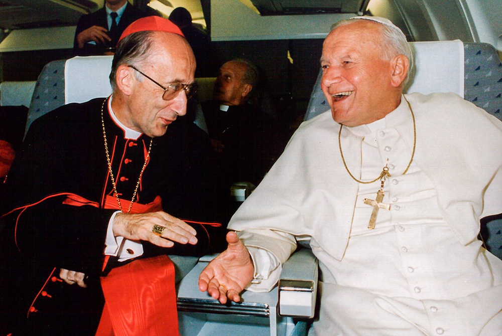 Pope John Paul II laughs while speaking with Italian Cardinal Camillo Ruini on board a papal flight in 1991. (CNS/L'Osservatore Romano/Arturo Mari)