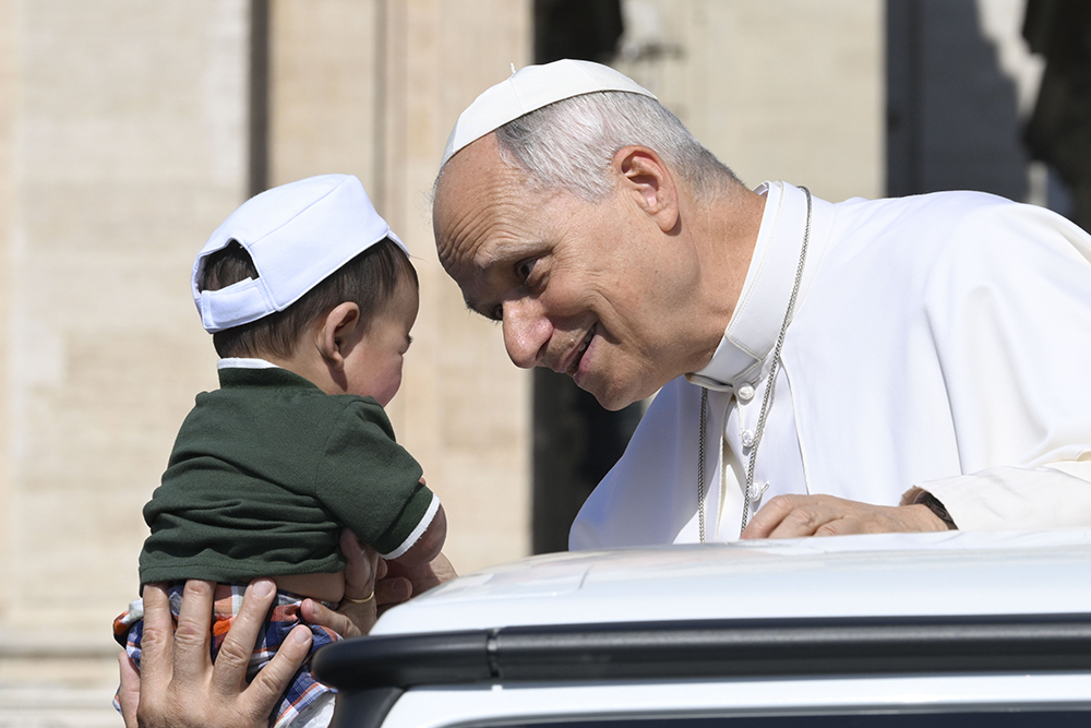 Pope Leo XIV greets a child from the popemobile while riding around St. Peter’s Square at the Vatican before his weekly general audience June 24, 2026. (CNS/Vatican Media)