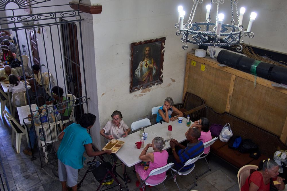 Carmen Casado, 84, is served a free meal of ground meat, rice, red beans and crackers through a program run by the Church of the Holy Spirit at a dining hall adjacent to the Catholic church in Old Havana, Cuba, , April 21, 2026. (RNS/AP/Ramon Espinosa)