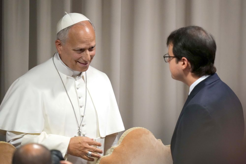 Pope Leo XIV speaks with to Christopher Olah, co-founder of the artificial intelligence company Anthropic, at the conclusion of a presentation on the pope's first encyclical, "Magnifica Humanitas: On Safeguarding the Human Person in the Time of Artificial Intelligence," at the Synod Hall at the Vatican May 25, 2026. (CNS/Lola Gomez)