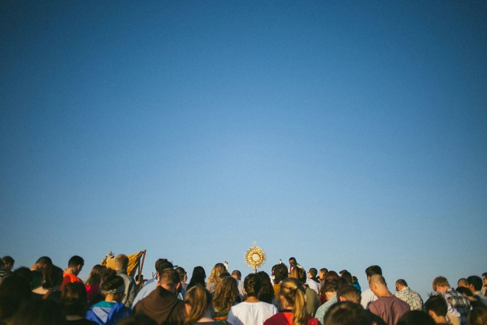 A group of people, including one person carrying a monstrance.