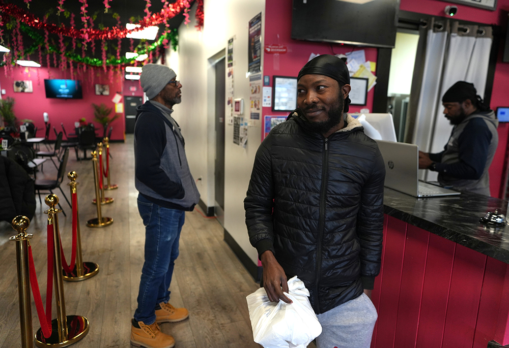 Roudechel Charpentier, a Haitian migrant who lives and works legally in the U.S. under Temporary Protected Status, walks out of the Rose Goute Creole restaurant, Feb. 3, 2026, in Springfield, Ohio. (AP photo/Luis Henao)
