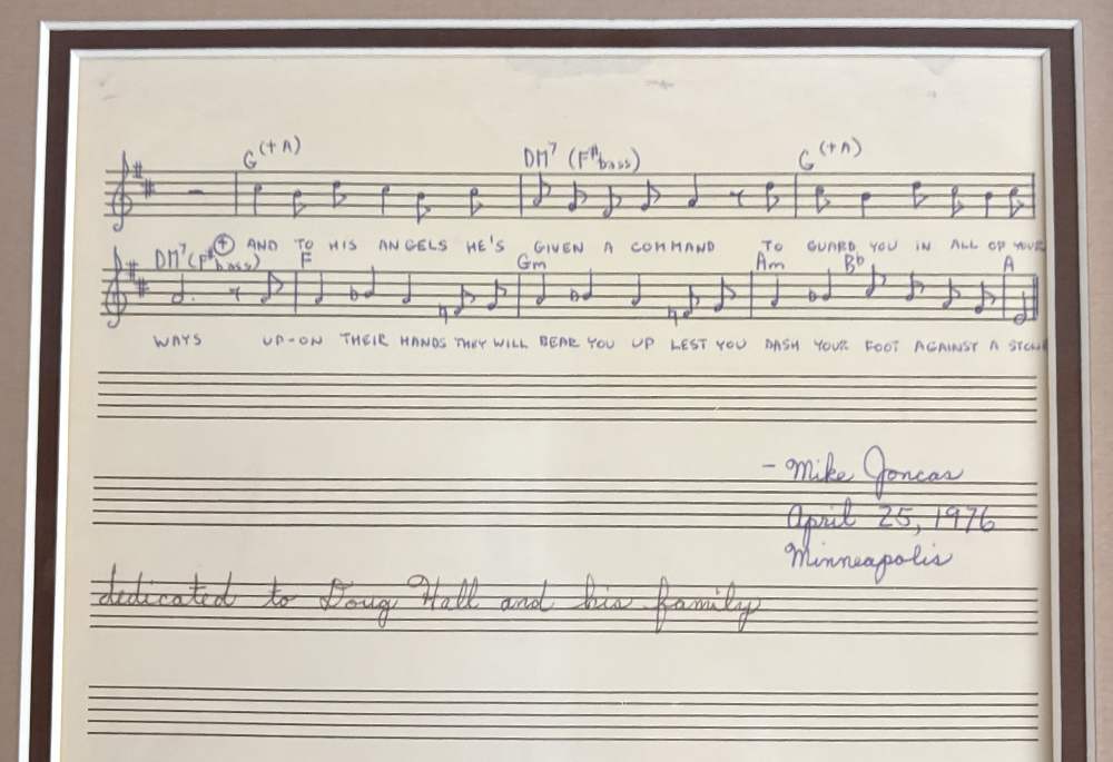 The original 1976 score of "On Eagle's Wings" by Fr. Michael Joncas is framed and displayed on his bookcase in his apartment in St. Paul, Minnesota, May 2026. (NCR photo/Camillo Barone)