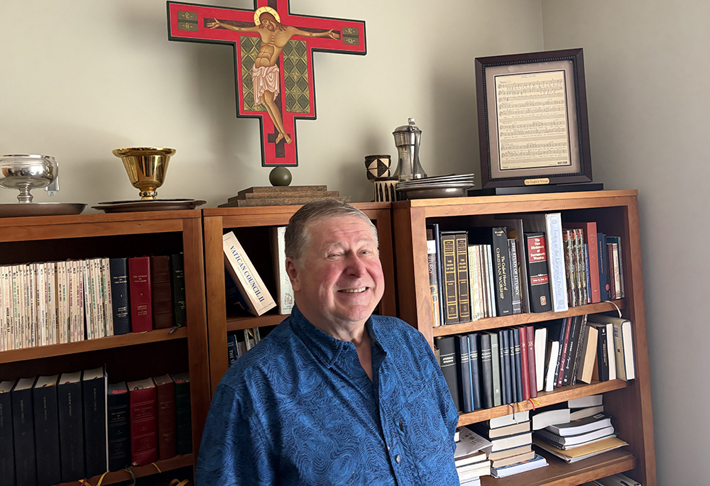 Fr. Michael Joncas poses by the original 1976 score of "On Eagle's Wings" in his apartment in St. Paul, Minnesota, May 2026. (NCR photo/Camillo Barone)