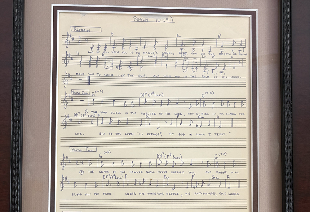 The original 1976 score of "On Eagle's Wings" by Fr. Michael Joncas, framed and displayed on his bookcase in his apartment in St. Paul, Minnesota, May 2026. (NCR photo/Camillo Barone)