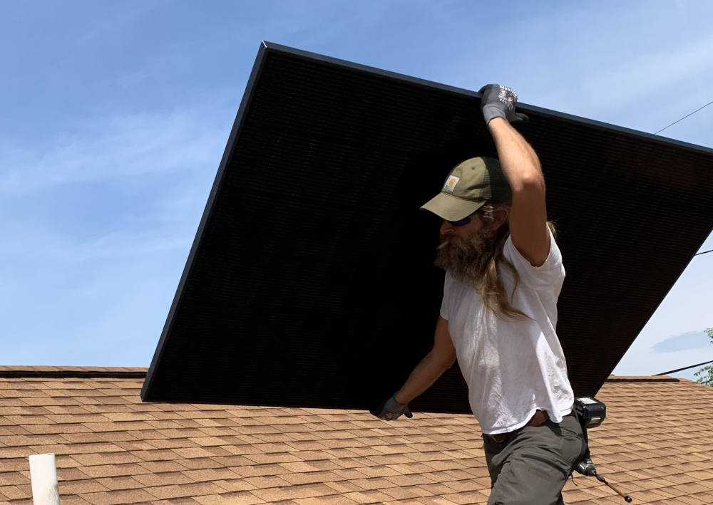 A worker carries a solar panel atop the roof of Mother of Good Counsel Catholic Church, in Hazard, Kentucky. The Appalachian mission parish completed the solar installation in May 2026. (Lexington Diocese/Joshua Van Cleef)