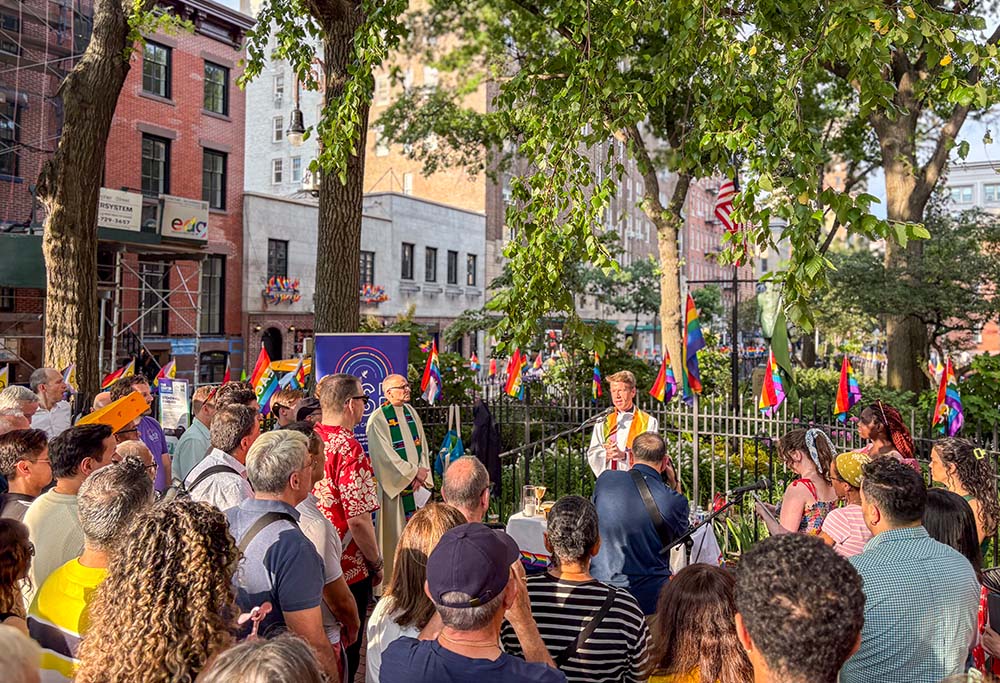 Worshippers pray at a Pride Mass organized by Out at St. Paul's, the LGBTQ+ ministry of St. Paul the Apostle in Manhattan, at the Stonewall National Monument in Christopher Park in New York, steps away from the Stonewall Inn, June 25, 2026. (NCR photo/Camillo Barone)