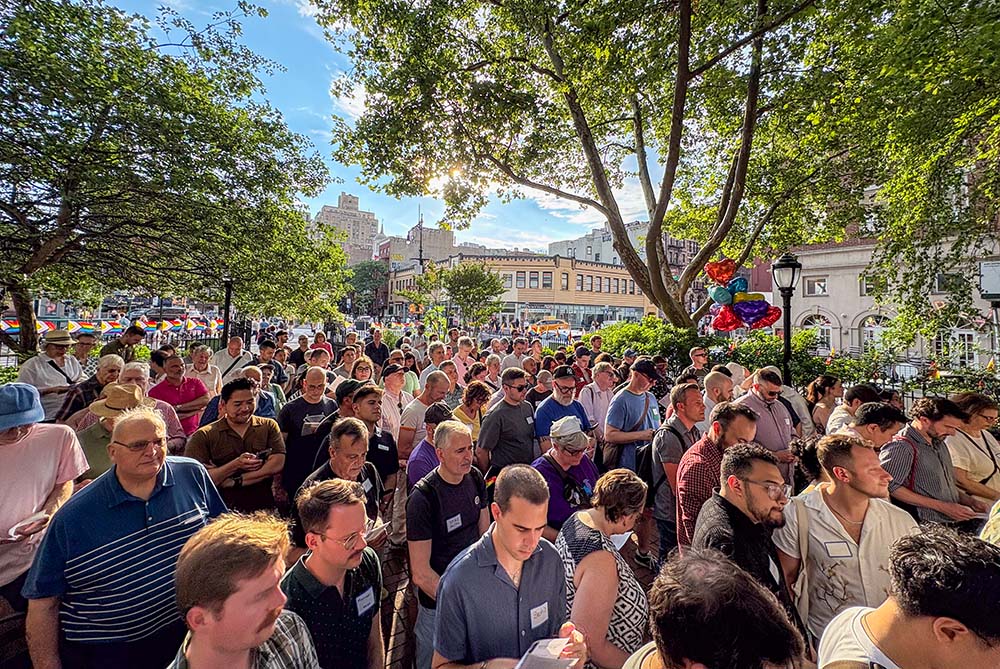 A crowd of about 150 worshippers and visitors stand at the Stonewall National Monument in Christopher Park in New York during an open-air Mass on June 25, 2026, steps away from the Stonewall Inn. (NCR photo/Camillo Barone)