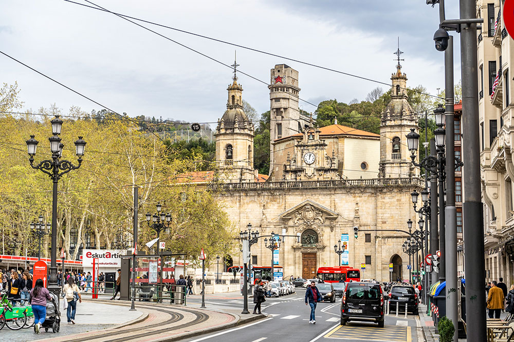 People and traffic are seen on a busy street in front of the Catholic Church of San Nicolas in Bilbao, Spain, March 28, 2024. (Dreamstime/Artem Stepanov)