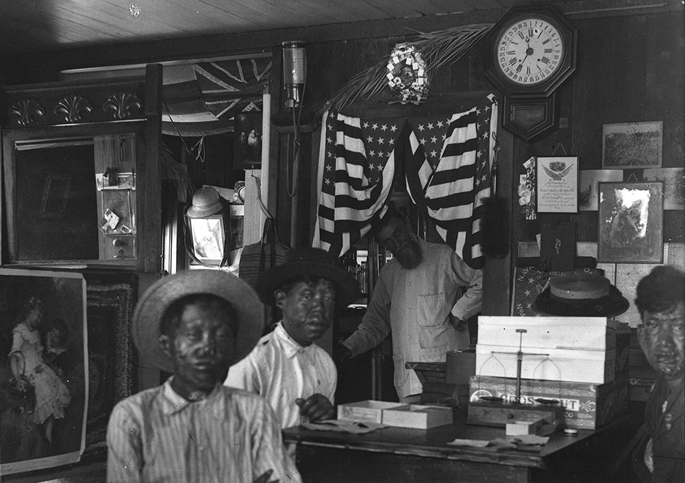An undated photo shows Joseph Dutton with leprosy patients in his office at the Baldwin Home for Boys in Kalawao Molokai, Hawaii. (Courtesy of Hawaii State Archives)