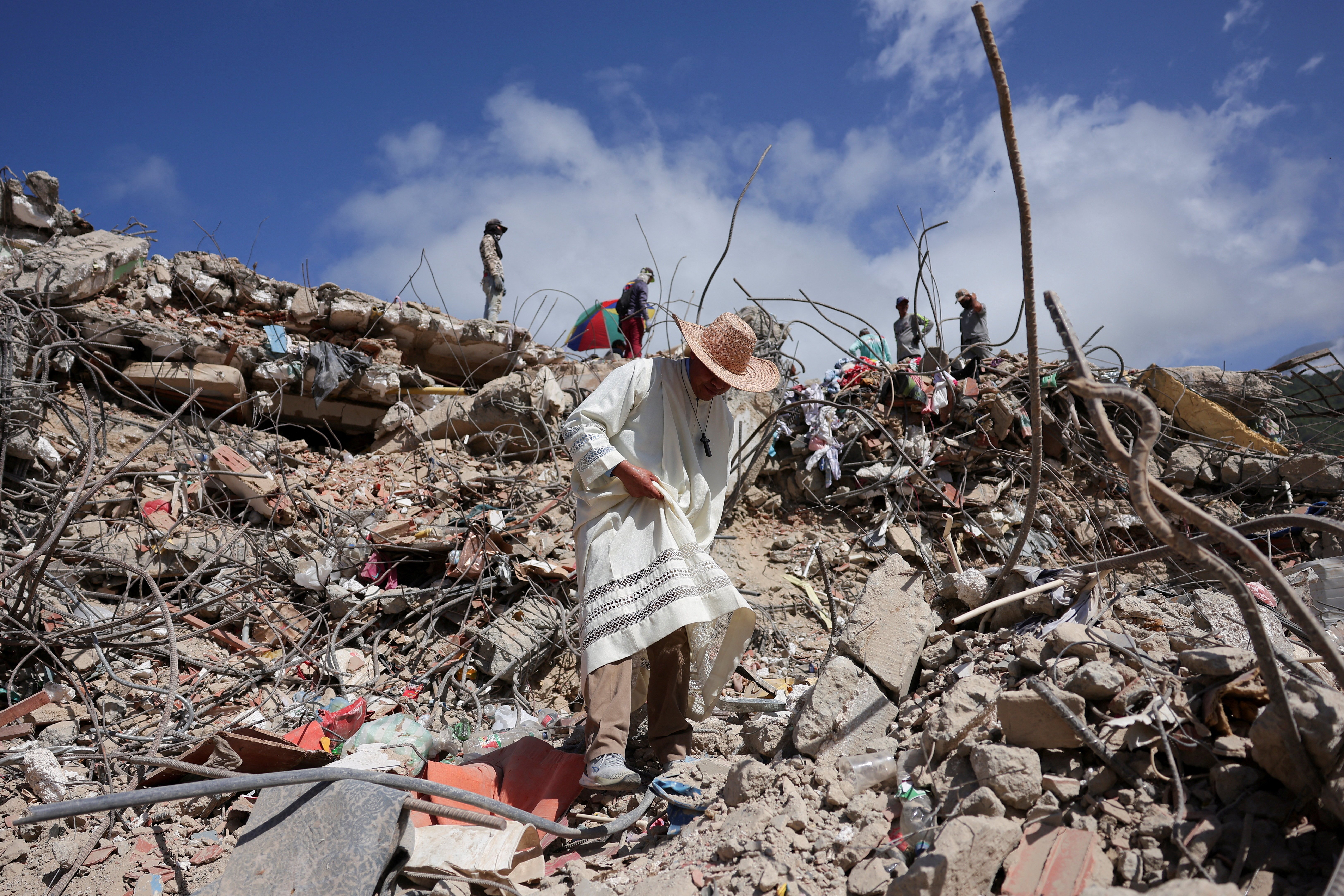 A priest walks through the debris of a collapsed building in La Guaira, Venezuela