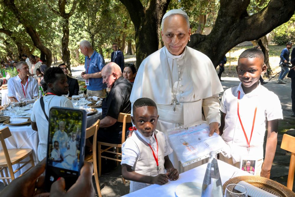 Pope Leo XIV poses for a photo with two young boys at a lunch with vulnerable people from the Diocese of Rome at Borgo Laudato Si, in the pontifical gardens of Castel Gandolfo, Italy, July 11, 2026. (OSV News/Vatican Media/Simone Risoluti)