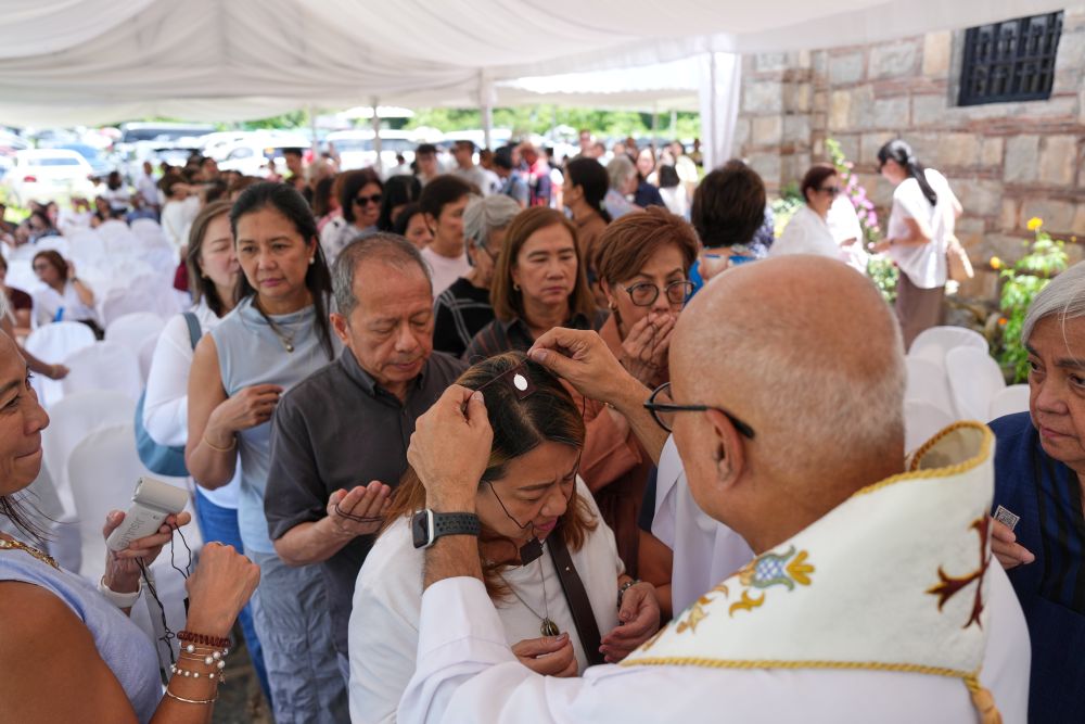 Fr. Dennis Paez places a scapular necklace on pilgrims during their visit at the Ephesus House, a replica of the House of the Virgin Mary in Ephesus, Turkey, at Alfonso town, Cavite province, Philippines on July 16, 2026. (AP/Aaron Favila)