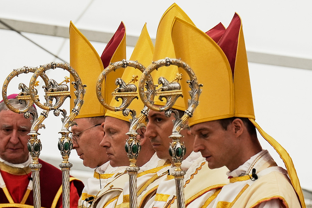 Newly consecrated Society of St. Pius X bishops, from left, Pascal Schreiber, Michael Goldade, Michel Poinsinet de Sivry and Marc Hanappier pray at the end of their consecration ceremony in a tent set up outside the Society of St. Pius X seminary in Écône, Switzerland, July 1, 2026. (AP/Baz Ratner)