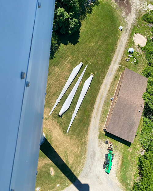 The blades for Portsmouth Abbey's wind turbine lie on the ground in 2026, waiting for repair after 20 years of function. (Courtesy of Joseph Byron)