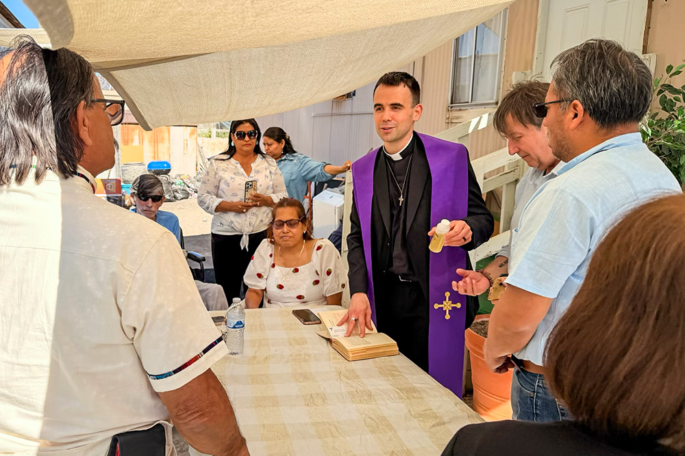 Fr. Mattia Ferrari, center right, visits local farmworkers and anoints the sick in California's Coachella Valley on June 21, 2026. (Courtesy of Catholics in Communion)