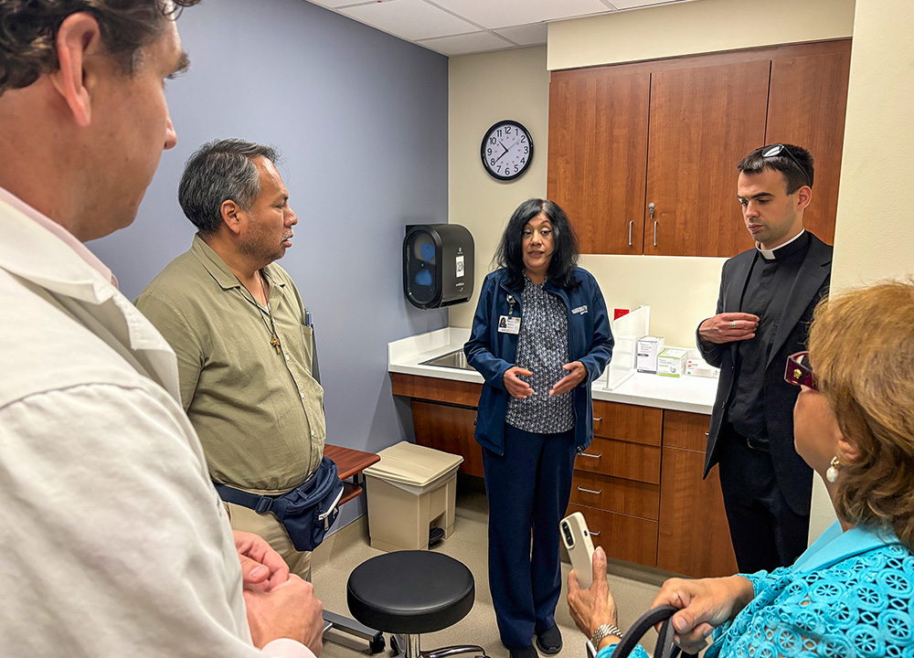 Fr. Mattia Ferrari, top right, and a touring delegation visit a dialysis center for people without insurance in Houston. (Courtesy of Industrial Areas Foundation)