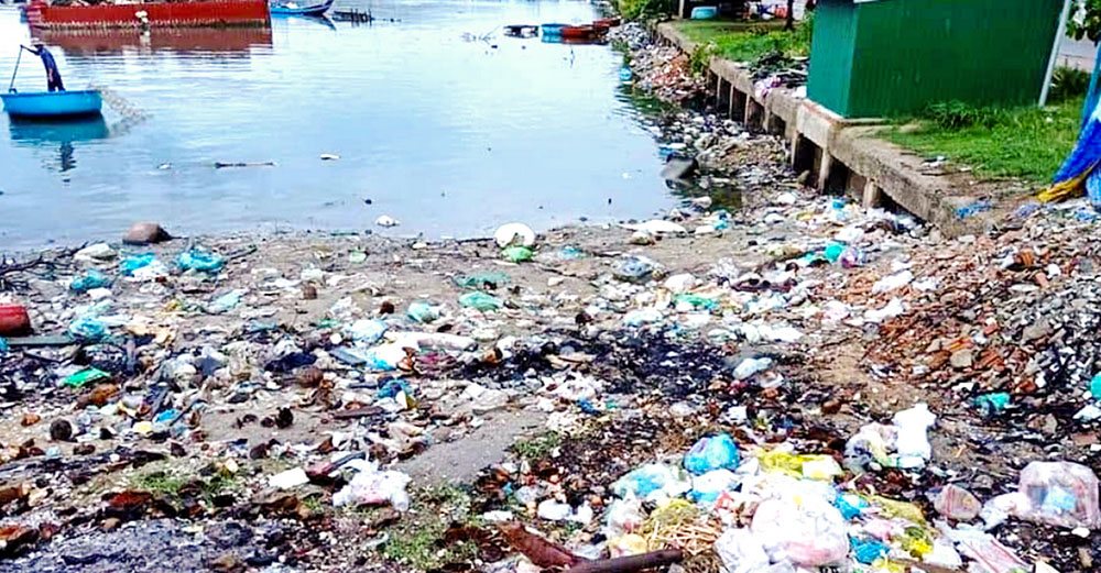 Plastic waste and other debris are discarded at Tam Giang Lagoon in Hue, Vietnam, on June 25, 2026. Seasonal floods often carry the trash into the sea. (Joachim Pham)