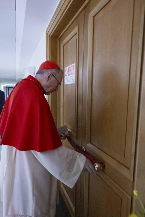 Cardinal Pietro Parolin, who served as Pope Francis' secretary of state, checks the seals on one of the doors of the suite of rooms used by Pope Francis in the Domus Sanctae Marthae, at the Vatican April 21, 2025. (CNS photo/Vatican Media)