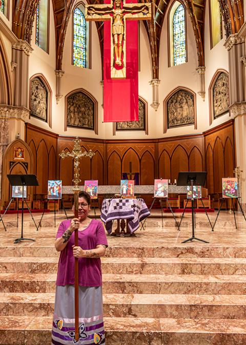 Toni Schunk, a member of the Mandan, Hidatsa and Arikara Nation, holds the crucifix during "Stations of the Cross: A Native American Catholic Journey of Healing and Reconciliation" at Holy Name Cathedral in Chicago. (Courtesy of Jody Roy)