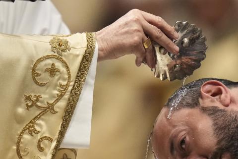 Giovanni Battista Re baptizes a man as he leads the Easter vigil inside St. Peter's Basilica at the Vatican, Saturday, April 19, 2025. (AP Photo/Alessandra Tarantino)