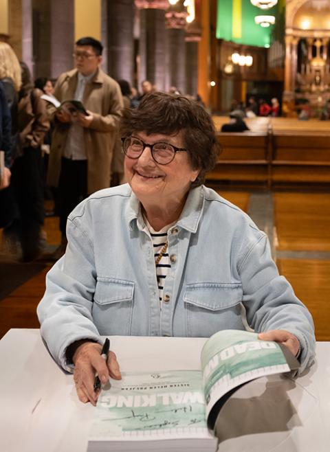 Sr. Helen Prejean autographs the graphic version of Dead Man Walking during a Nov. 6, 2025, book launch at St. Paul the Apostle Church in Manhattan, sponsored by the Fordham Center on Religion and Culture. (Fordham University/Leo Sorel)