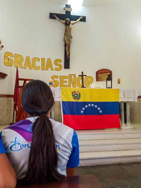 A young woman from Proyecto Líderes prays before the altar at St. Francis Xavier Parish in Porlamar, Venezuela, in July 2026. (Courtesy of Maura Aranguren)