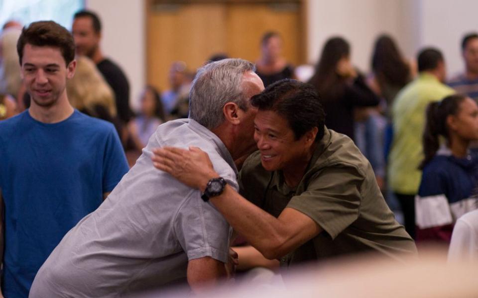Person hugs another.