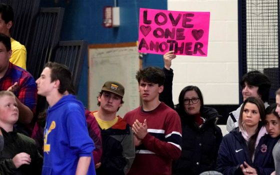 A woman displays a sign during a vigil May 8 for victims of a shooting the day before at the STEM School Highlands Ranch in Colorado. (CNS/Reuters/Rick Wilking)