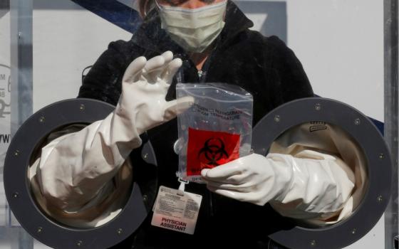 Physician Assistant Cori Kostick demonstrates the Brigham B-PROTECTED testing booth used to administer tests for COVID-19 at the Brigham and Women's Hospital community testing site in Boston May 5. (CNS/Reuters/Brian Snyder)