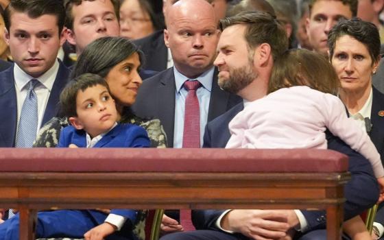U.S. Vice President JD Vance, holding their daughter, smiles with his wife, Usha, who is holding their son, before the start of the Liturgy of the Lord's Passion in St. Peter's Basilica at the Vatican April 18, 2025. (CNS photo/Lola Gomez)