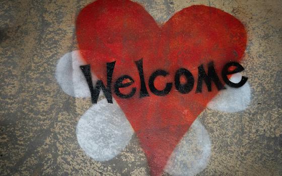 A red heart is displayed spray painted on a tan wall in this photo illustration. (Unsplash/Nick Fewings)