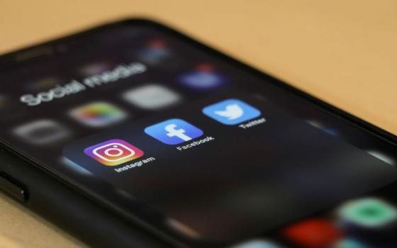 cell phone screen shows social media icons.