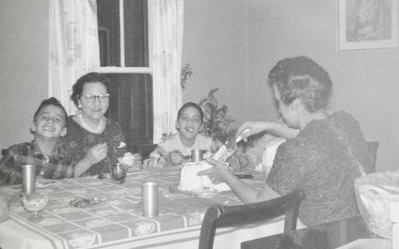 In this undated photo, Pope Leo XIV (then Robert Prevost, left) smiles while his mother (back to the camera) cuts a birthday cake in what his brother (right) guessed was the pope's ninth birthday, at the family home in the Chicago suburb of Dolton. (OSV News/Prevost family)