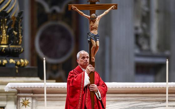 Pope Leo XIV holds a crucifix as he leads the Good Friday Liturgy of the Lord's Passion in St. Peter's Basilica at the Vatican April 3, 2026. (OSV News/Reuters/Guglielmo Mangiapane)