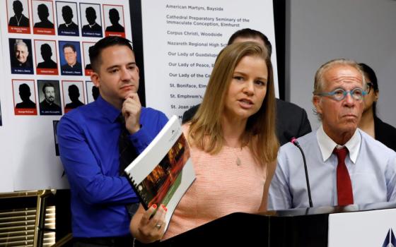 Clergy sex abuse victim Joseph Caramanno, left, and attorney Jeff Anderson listen as Bridie Farrell addresses a news conference in New York Aug. 14, 2019. Caramanno accused Msgr. John Paddack of child sex abuse and sued the Archdiocese of New York in August 2019. (AP/Richard Drew)