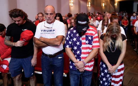 Audience members stand and pray before Republican presidential candidate former President Donald Trump arrives to deliver remarks on the tax code, and manufacturing at the Johnny Mercer Theatre Civic Center Sept. 24, 2024, in Savannah, Ga. (AP/Evan Vucci)