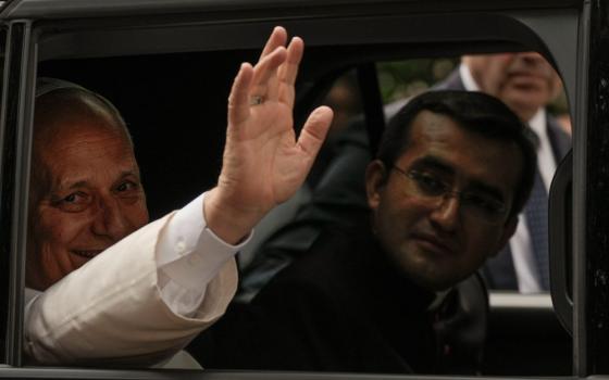 Pope Leo XIV waves from his car as he leaves with his personal secretary, Msgr. Edgard Iván Rimaycuna Inga, right, after visiting the Città Universitaria (University City) at Sapienza University of Rome May 14, 2026. (AP/Gregorio Borgia)