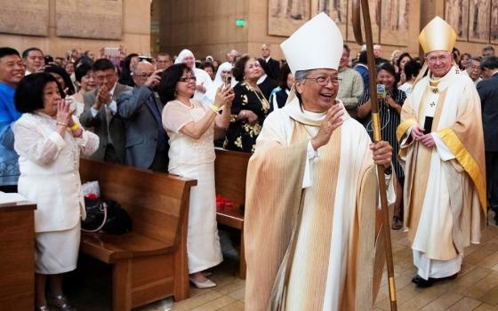 Auxiliary Bishop Alejandro "Alex" Aclan waves to the congregation during his episcopal ordination at the Cathedral of Our Lady of the Angels in Los Angeles May 16, 2019. Archbishop José Gomez is at right.  Pope Leo XIV accepted the resignation of Aclan, 75, on May 22, 2026. (OSV News/Angelus News/Victor Aleman)