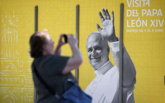 A woman in Madrid takes a picture of a poster of Pope Leo XIV May 28, 2026, ahead of the pontiff's June 6-12 apostolic visit to Spain. (OSV News/Reuters/Kacper Pempel)
