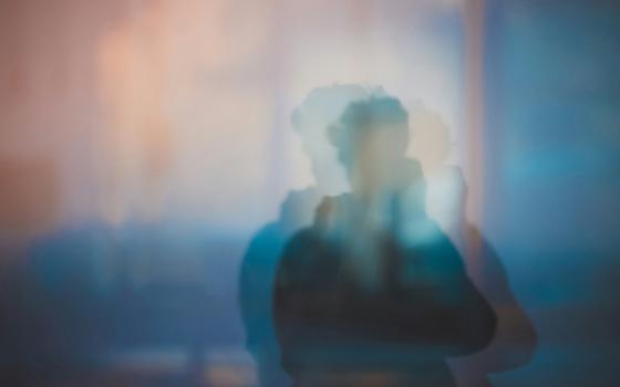 A photo illustration shows a blurry image of a person in silhouette, distorted with duplicate overlapping images of that same person, against a background that contains warm colors above and cooler colors below. (Unsplash/Xiangkun ZHU)(Unsplash/Xiangkun ZHU)