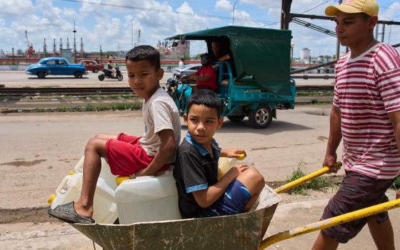 A man transports containers of water with his children in Havana May 28, 2026. (AP/Ramon Espinosa)