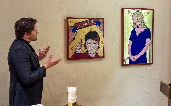 Jesuit artist Fr. Nicholas Leeper shows the artworks "The Crucifixion (Kiss it Better with Band-Aid)" and "Madonna del Parto (Once Upon a Time ... In Bethlehem)" during a press walkthrough for his exhibition "Twilight of the Idols" in St. Mary Chapel at St. Francis Xavier Church in New York, May 13, 2026. (NCR photo/Camillo Barone)