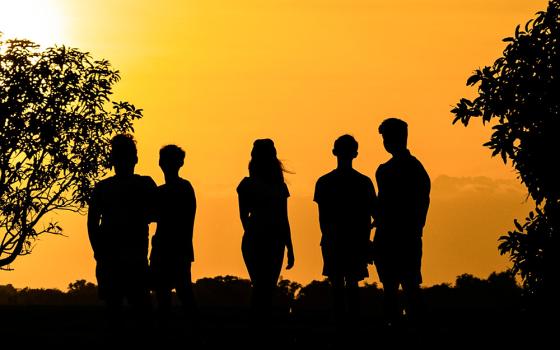 A group of people looking out at the horizon (Unsplash/Marc Clinton Labiano)