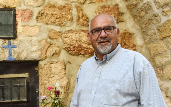 Zoughbi Zoughbi poses for a photo May 4, 2019, near the door of a cave that was the ancestral home of his family in Bethlehem, West Bank. (CNS/Debbie Hill)