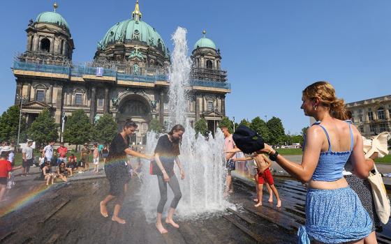 People cool off in a fountain in front of the Berlin cathedral during a heat wave July 19, 2022. (CNS/Reuters/Fabrizio Bensch)