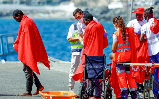 Migrants are treated by Red Cross volunteers after disembarking from a Spanish coast guard vessel at the port of Arguineguin, on the island of Gran Canaria, Spain, Aug. 28, 2024. (OSV News/Reuters/Borja Suarez)