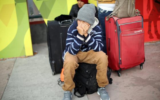 A young asylum-seeker sits on his backpack in Tijuana, Mexico, April 25, 2019, before crossing to the U.S. (OSV News/Reuters/Andres Martinez Casares)